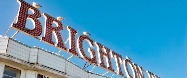 Vibrant "Brighton Pier" sign set against a blue sky