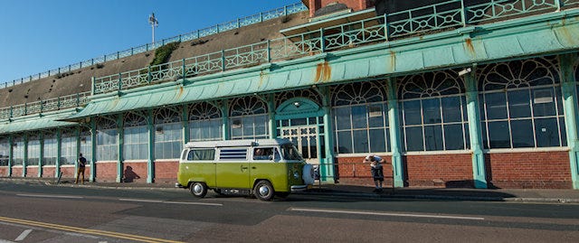 VW campervan parked outside a large building