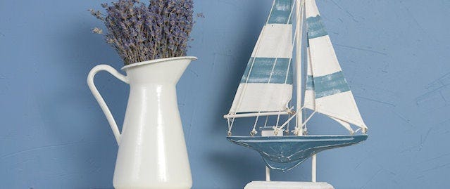 A decorative jug and model boat on a shelf