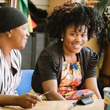 Two smiling ladies in a community centre 