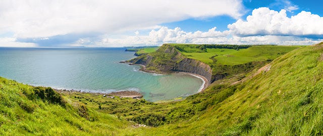 Looking down on a bay that is surrounded by green fields