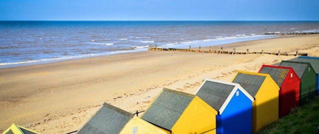 a row of beach huts facing the sea