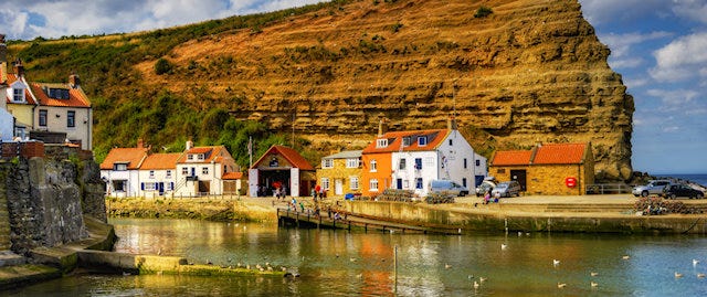 Staithes coast, with cottages dotted before a large cliffside