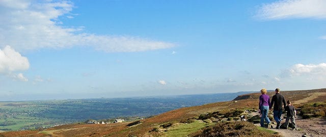 Family walking a path with a view over the Yorkshire Moors