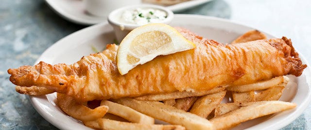 Plate of fish and chips with a lemon slice on top