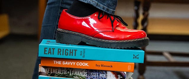A red shoe standing on pile of healthy-eating books