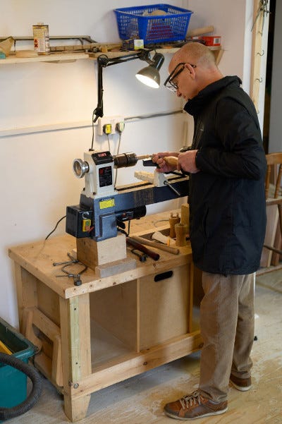 An adult working at a woodworking table