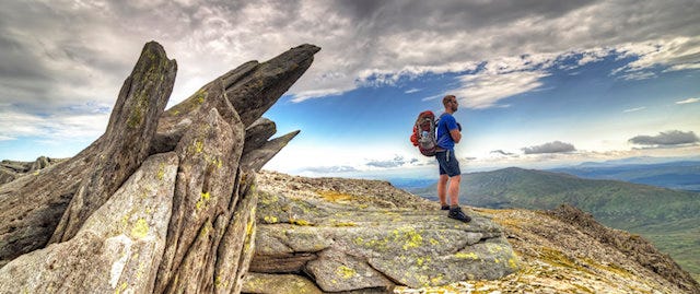 Man standing looking over hills