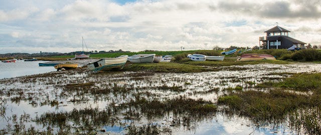 Boats resting on the land during low tide at Morston Quay