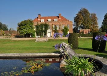 View across the pond and the formal gardens to large stately house