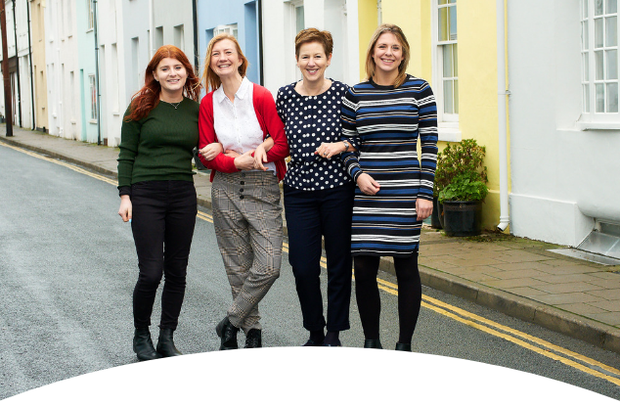 4 ladies standing in front of the colourful houses in brighton 