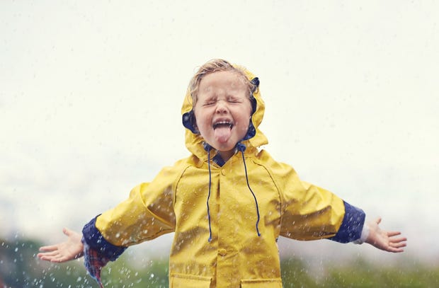 Boy in the rain in yellow raincoat