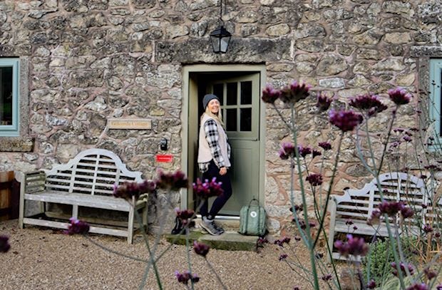 A lady entering a stone-faced country property