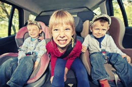 Three bored children in a car