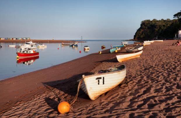 boats on the beach at sunset