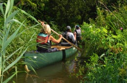 Canoe in the water with lady paddling