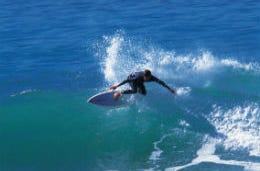 Surfer riding a high wave in Newquay on the Cornish Coast