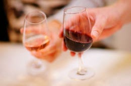 People eating out in Cornwall, toasting with red wine glasses