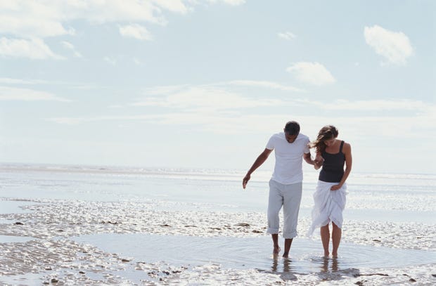Romantic couple walking along the shore