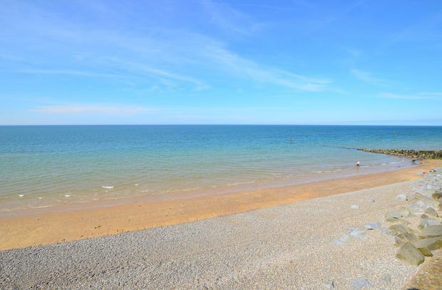 Clear blue sky and the sun shining on a beautiful sandy beach