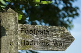 Public footpath signpost showing the way to Hadrian's Wall