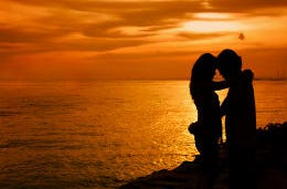 A couple embracing silhouetted against the sunset