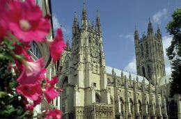 A picture of the magnificent Canterbury Cathedral bordered by pink flowers.
