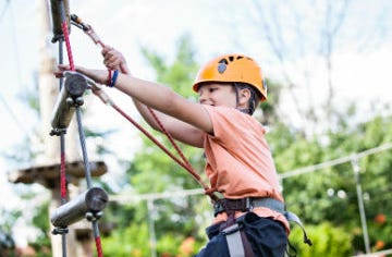A young boy climbing in the free adventure playground