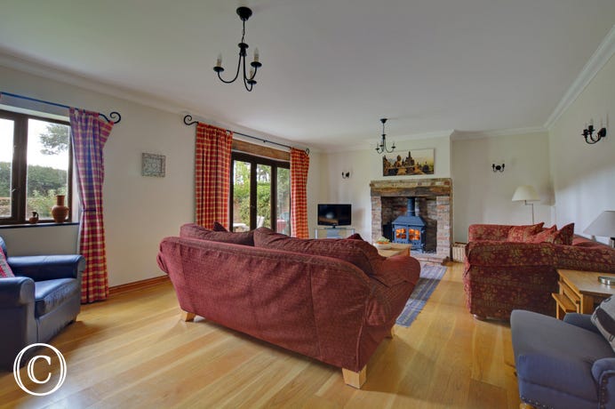 Light and spacious sitting room with large wood burner and french doors to the garden