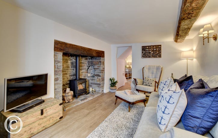 Attractive beamed living room with a woodburner in an inglenook providing a cosy focal point