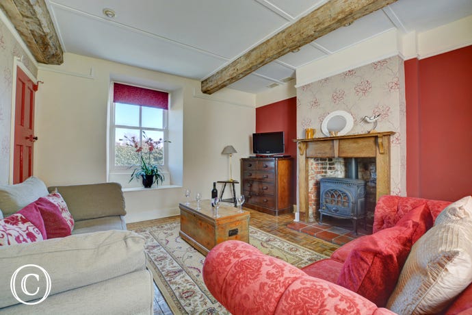 Characterful sitting room with parquet flooring, original beam and wooden fire surround
