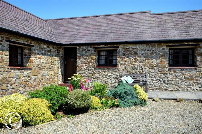 WAV324 - Exterior Wishing Well is in the corner of this L shaped group of cottages