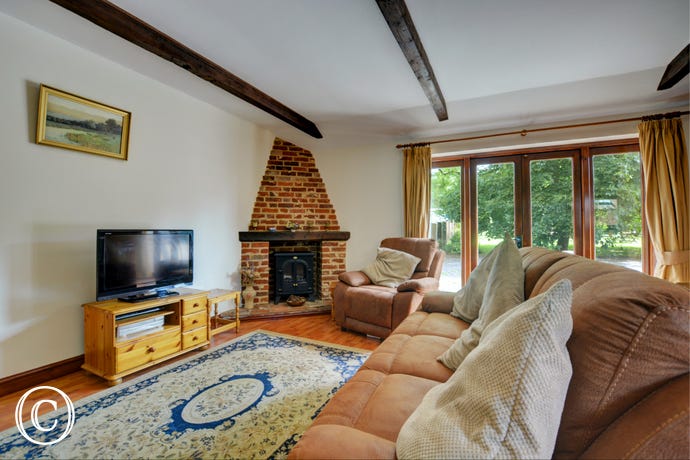 Spacious with a feature fireplace, french doors and lovely beams