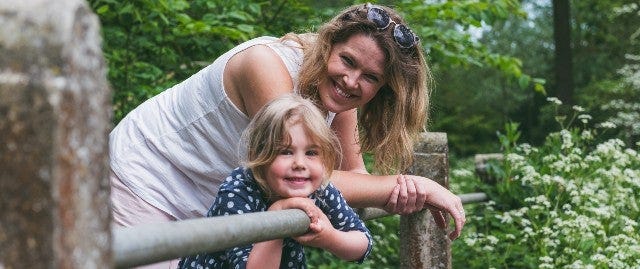 Mother and daughter posing on a bridge